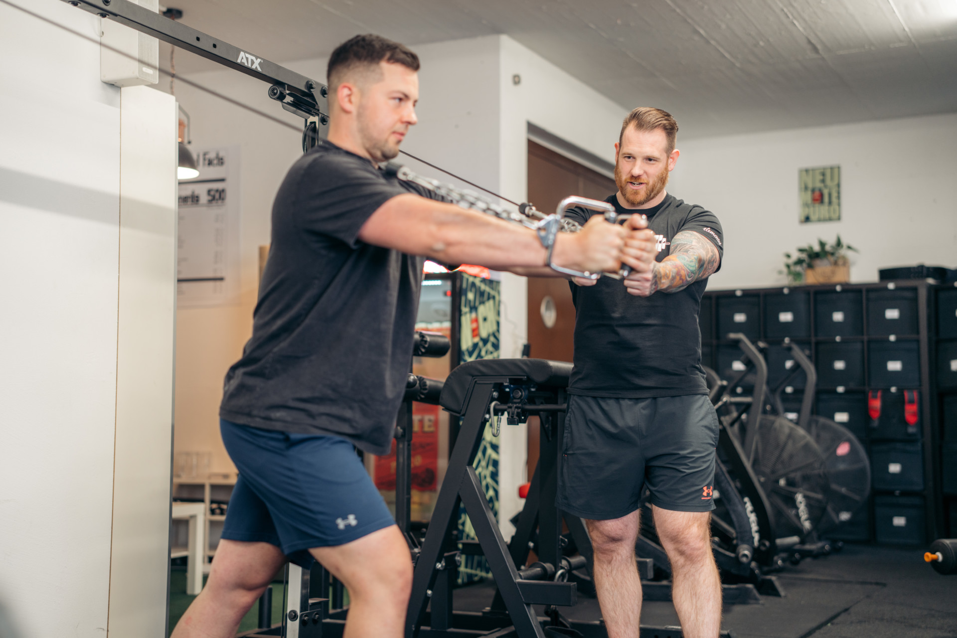 Person beim Trainieren mit Unterstützung eines Personal Trainers im Gym in Luzern